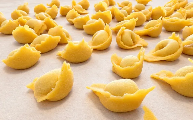 Cappelletti appena chiusi a mano, in fila sul tagliere infarinato ad asciugare