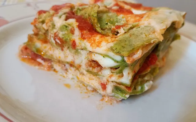 Porzione di lasagne al forno con gli strati di sfoglia e ripieno in vista