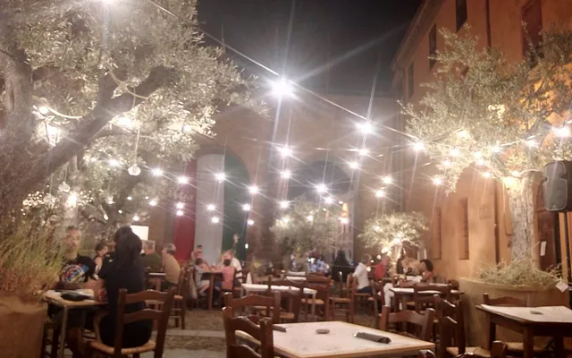 Tavoli apparecchiati sotto le luci nella corte della Rocca di Forlimpopoli, durante la Festa Artusiana