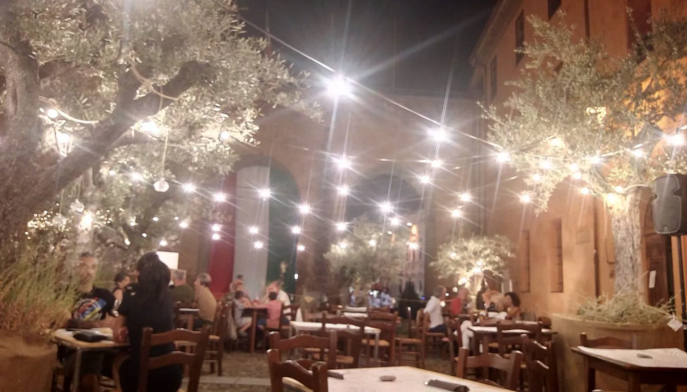 Tables laid under the lights in the courtyard of the Rocca in Forlimpopoli, during the Festa Artusiana