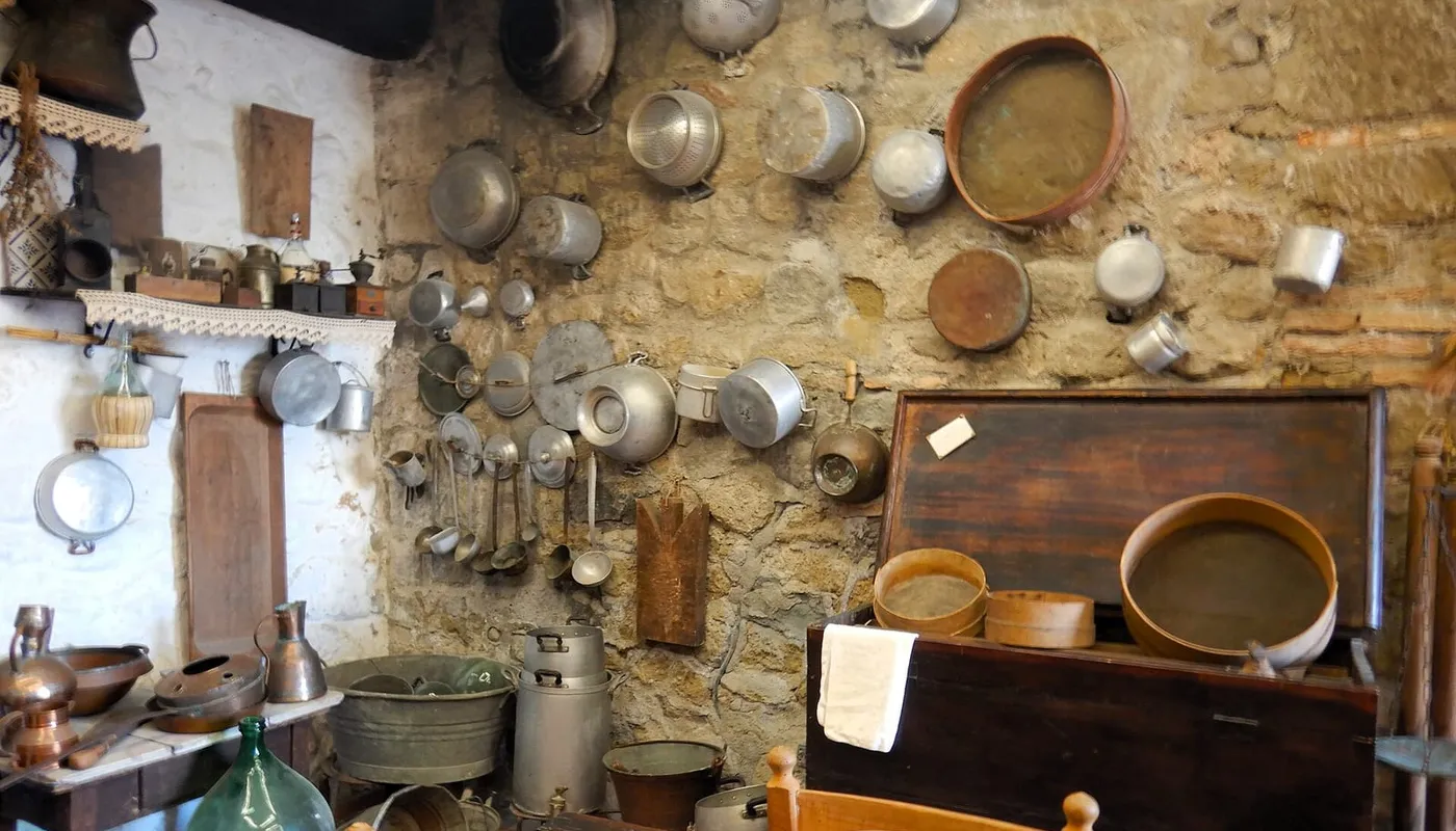 Cucina contadina romagnola d'epoca con tavolo, camino e utensili di rame