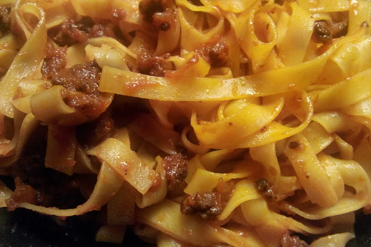 Tagliatelle all'uovo condite con il ragù, viste da vicino nel piatto