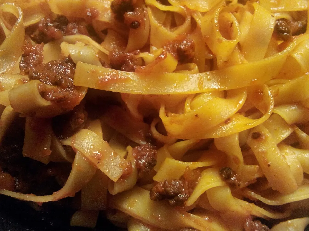 Tagliatelle all'uovo condite con il ragù, viste da vicino nel piatto
