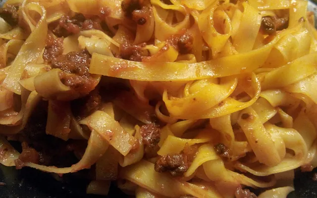 Tagliatelle all'uovo condite con il ragù, viste da vicino nel piatto