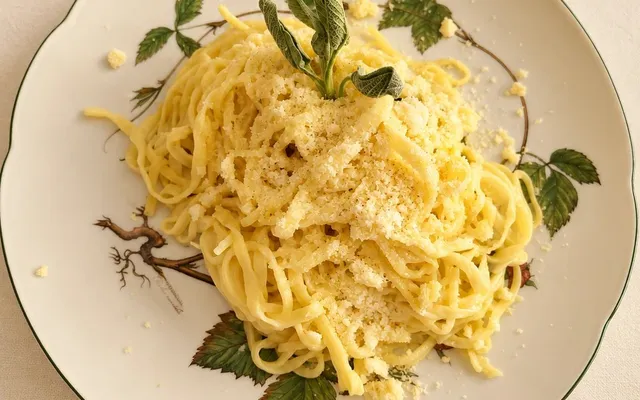 Tagliolini al burro e salvia con il parmigiano, nel piatto decorato a foglie